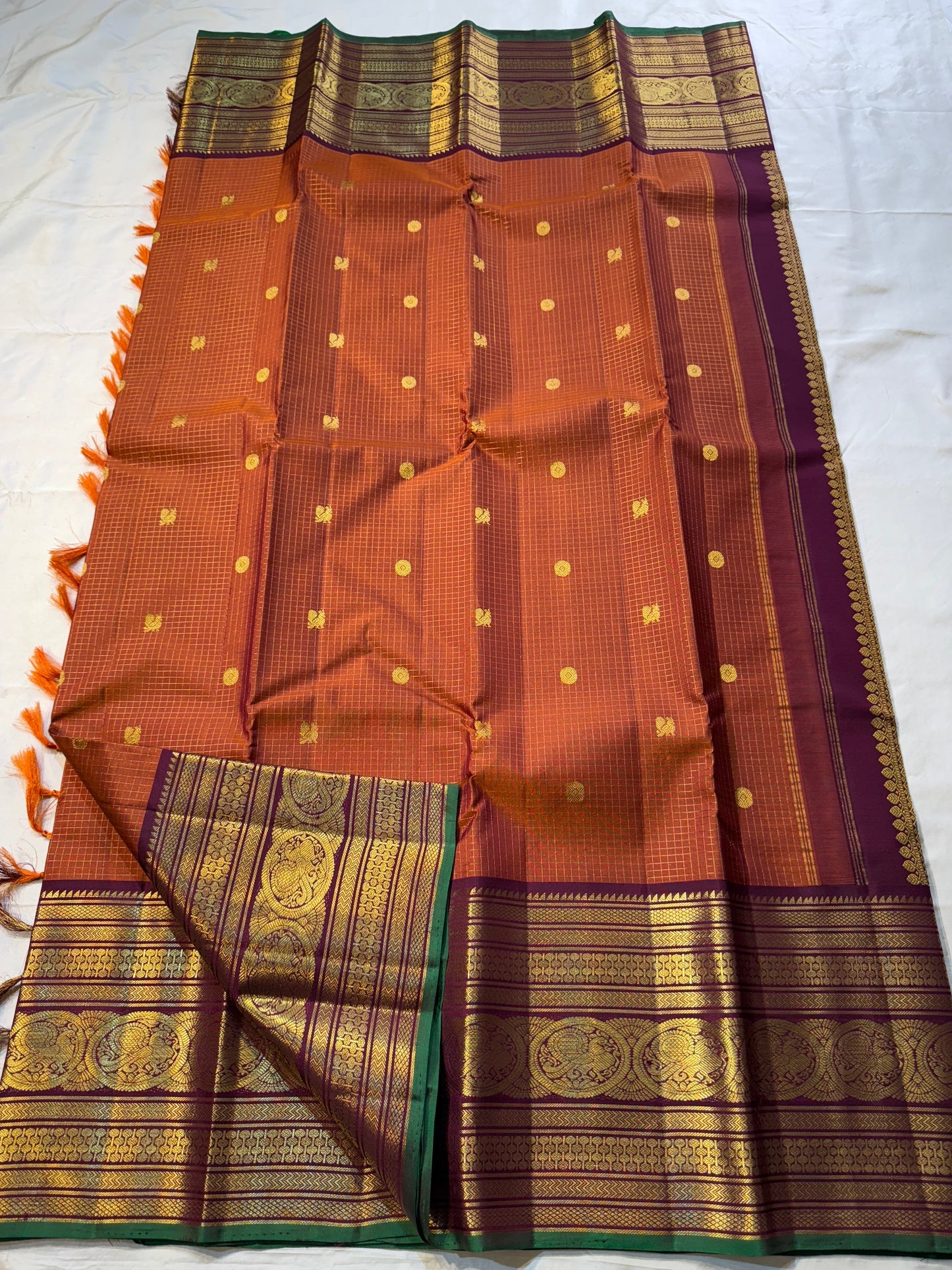 Rust Orange Pakshi Kattam – Pure Korvai Kanchipuram Silk Saree
Rust-orange micro-checked body with zari rosette & mango buttas
Plum korvai border with pakshi medallions & emerald selvedge; ships in two w
Silk Mark Certified | blouse Stitching available
