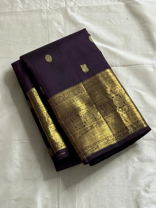 Deep Plum Coin Zari (Pure Kanchipuram Silk)
 Aubergine/plum body with gold chakram & mayil buttas
Self deep-purple border with antique-gold kasu-mālai (coin) motifs
Silk Mark Certified • Free USA Shipping • Ships in Two Weeks