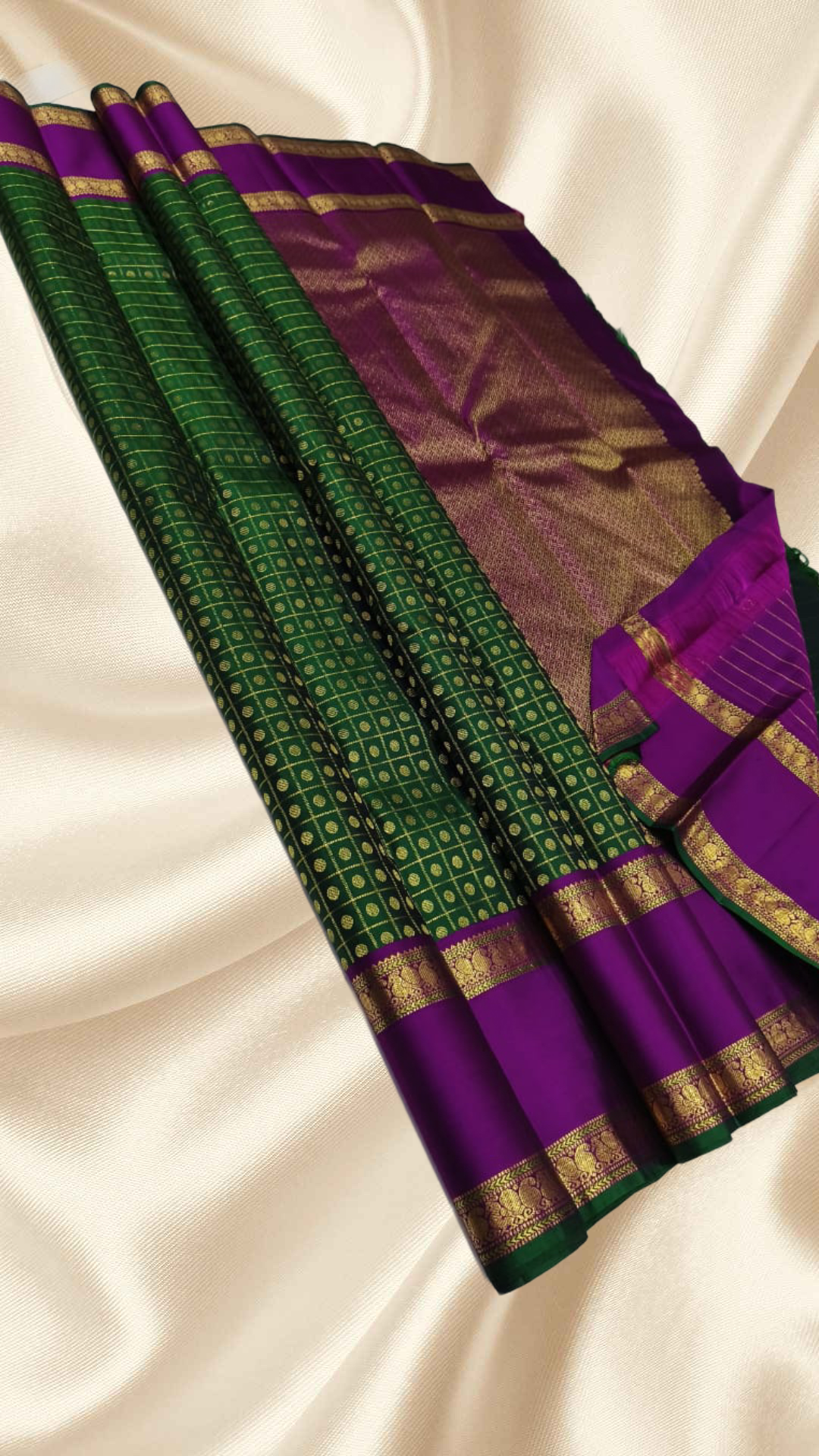 An heirloom-worthy drape woven in the finest 2G pure silk, this traditional Kanchipuram saree brings together the timeless beauty of zari buttas and checks in a rich green body. The contrast purple rettapet border stands bold and elegant