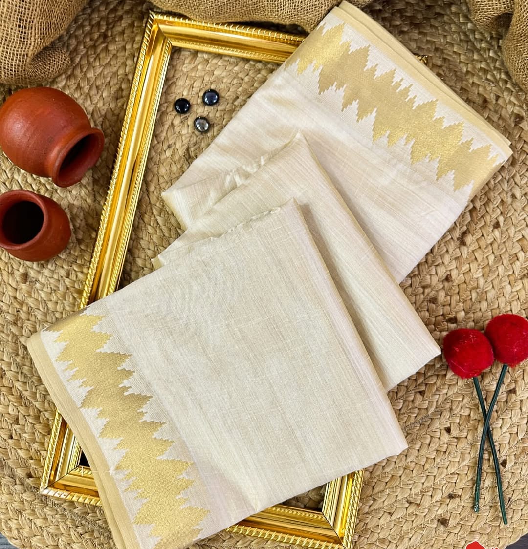 Minimal yet majestic, this ivory-beige silk saree is a celebration of simplicity and sophistication. The body is plain and luminous, texture of the silk shines through. golden zari border with a sharp, zigzag temple-inspired pattern - perfect for Onam
