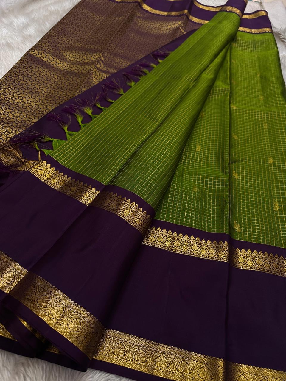 Iravati – Earthy Green Kanchipuram Pure Silk Saree
A graceful weave in a rare earthy green tone, adorned with gold zari kattam and butta.
Accented by a rich plum rettapet border with delicate flower vine motifs.