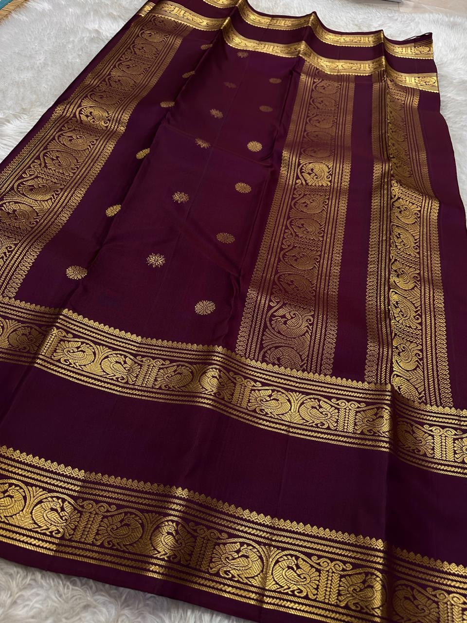 Saanvi – Lotus Pink & Magenta Shot Kanchipuram Silk Saree
Saanvi features zari buttas of mayils and chakrams across the body. A deep wine rettapettu border showcases twin peacocks in a temple arch. The pallu mirrors this grandeur with sorgavasal motifs !