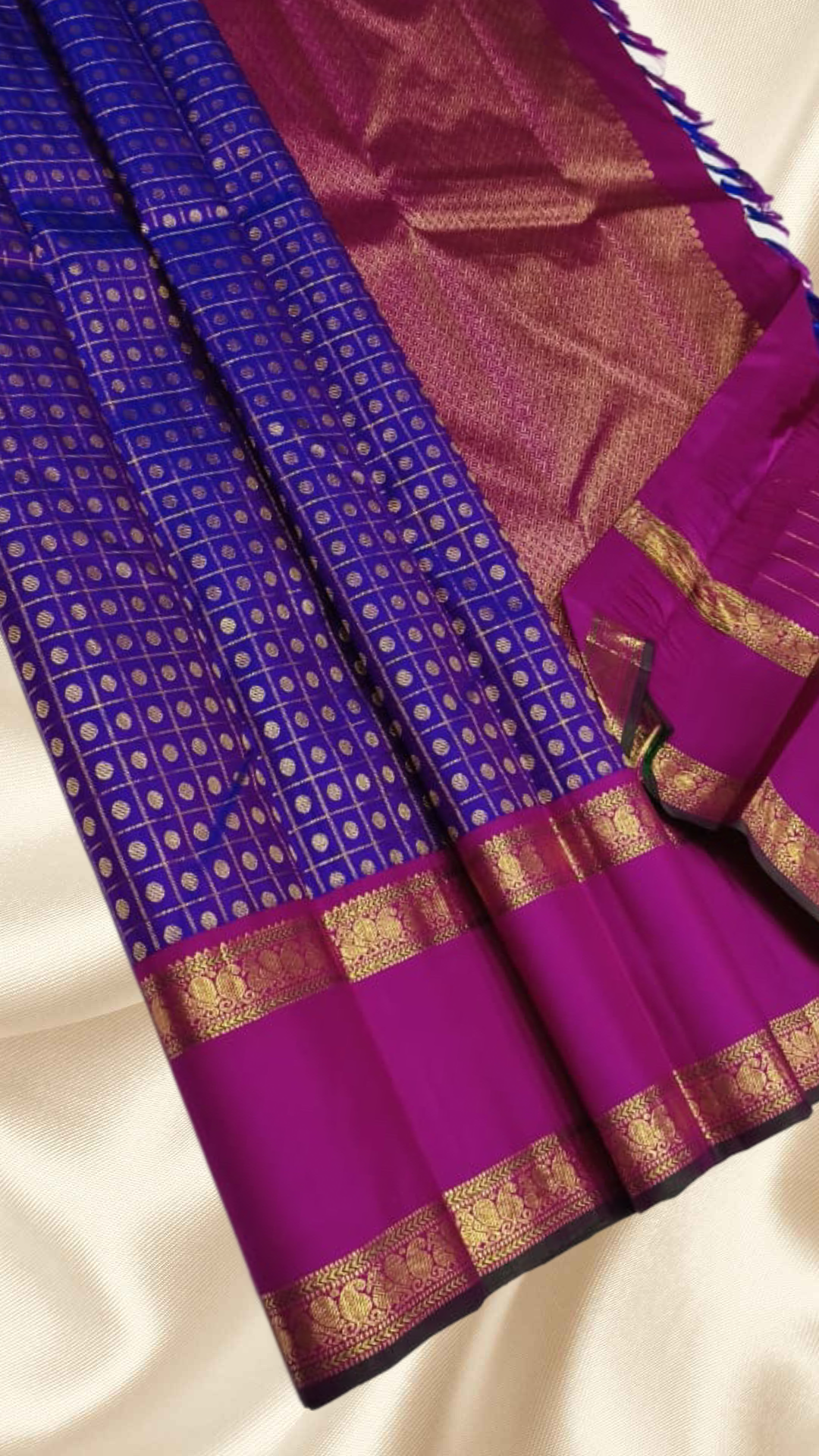 An heirloom-worthy drape woven in the finest 2G pure silk, this traditional Kanchipuram saree brings together the timeless beauty of zari buttas and checks in a rich purple body. The contrast magenta-pink rettapet border stands bold and elegant