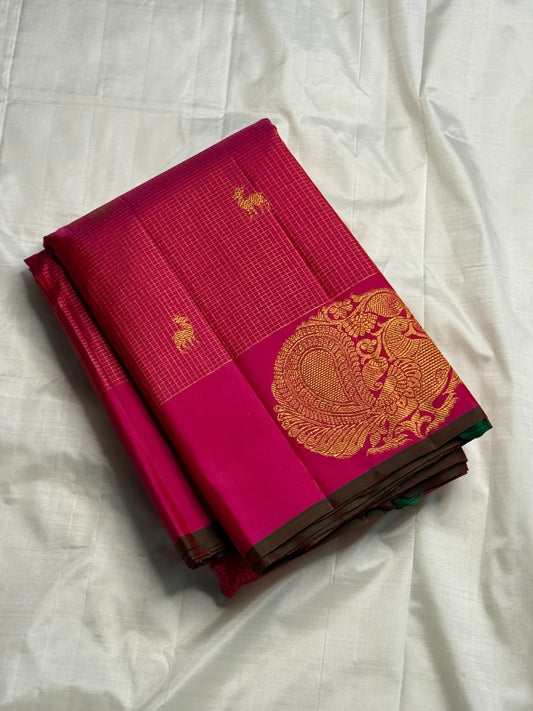 Peacock Arch Zari Kattam — Pure Silk Kanchipuram Saree
Magenta–Rani pink body with fine zari kattam checks & gold peacock motifs • Rust-orange brocade pallu with grand zari weave • Contrast selvedge & rich korvai borders
✨ Silk Mark Cert • Fall & Pico ✅