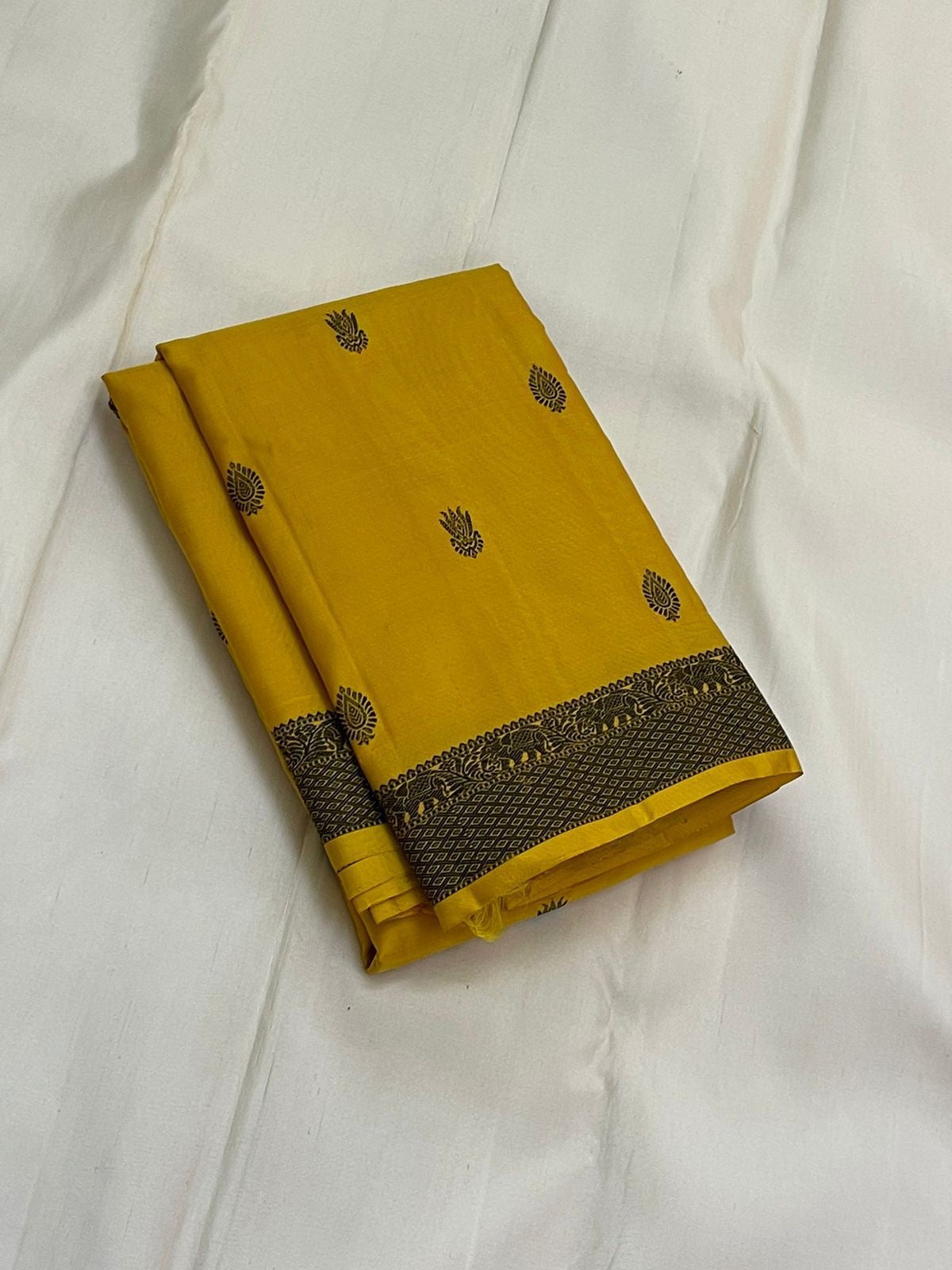 Marigold – Pure Kanchipuram Silk Saree
Haldi yellow body with charcoal paisley buttas
Contrast charcoal border in silk thread, floral vine
Silk Mark Certified | Blouse Piece Included | Fall & Pico Done
Free Shipping within USA | Ships in 2 Weeks