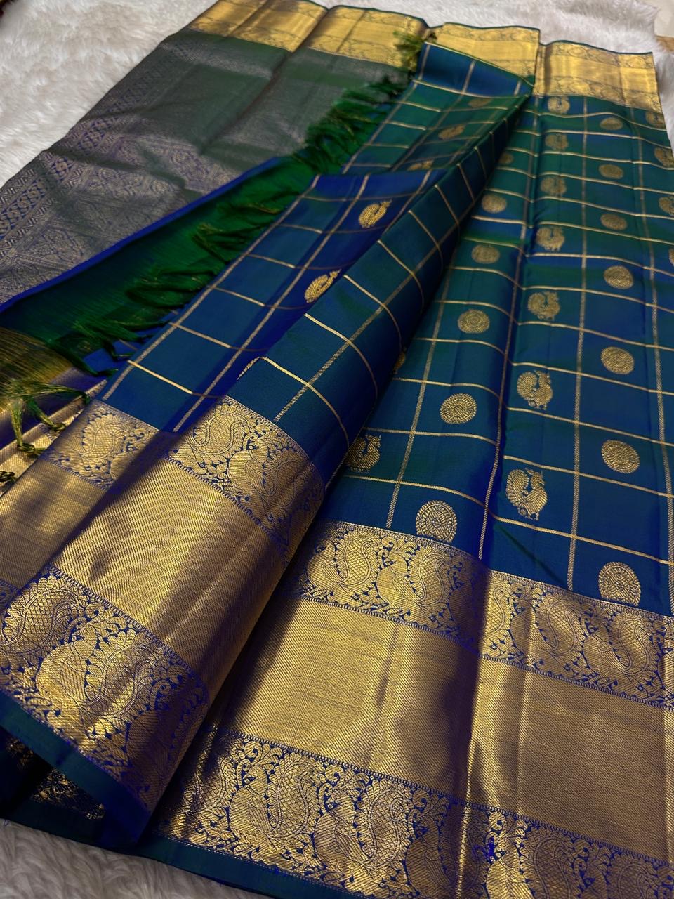 Nemali Zari Checks | Pure Silk Kanchipuram
Peacock-Blue & Emerald-Green Dual Tone • Zari Checks with Buttas
Gold Zari Borders with Paisley Motifs • Rich Brocade Pallu
Silk Mark Certified • Free Shipping within USA
Ships in Two Weeks | Blouse Sti