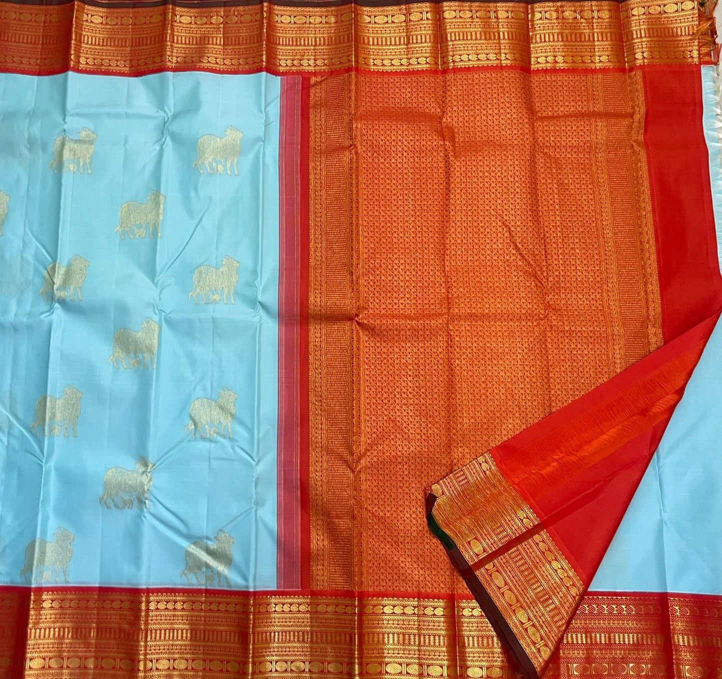 Kamadhenu — Pure Silk Kanchipuram
Sky-blue body with gold Kamadhenu motifs, fiery-orange pallu & ruby-red korvai borders ✨
Silk Mark Certified • Antique Zari Weave • Ships in Two Weeks • Free Shipping within USA