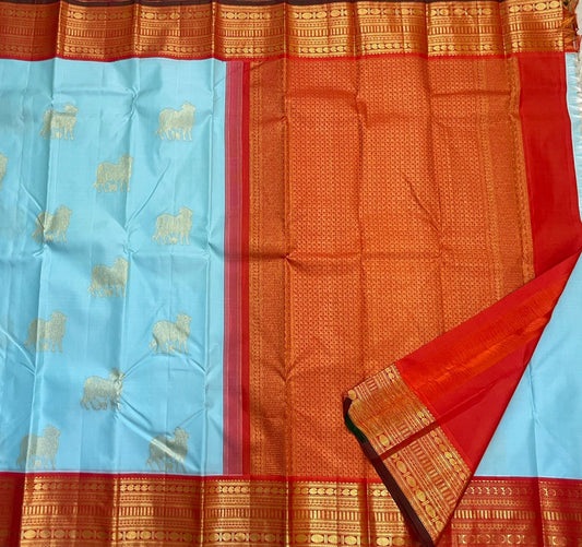 Kamadhenu — Pure Silk Kanchipuram
Sky-blue body with gold Kamadhenu motifs, fiery-orange pallu & ruby-red korvai borders ✨
Silk Mark Certified • Antique Zari Weave • Ships in Two Weeks • Free Shipping within USA