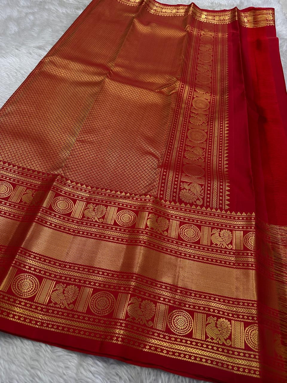A true festival essential white with dashing red pure silk Kanchipuram saree with a kamalam and mayil detailed border zari work , red reku and Pallu