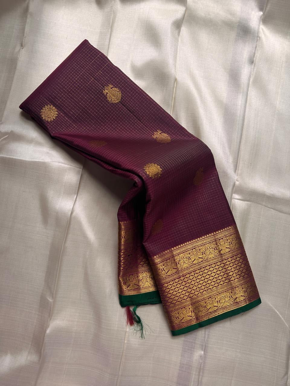 Madhuvanam — Pure Silk Kanchipuram Saree
Brownish-plum body with gold buttas & kattam checks ✨
Antique-gold korvai borders & grand magenta zari pallu 🌸
Silk Mark Certified • Ships in Two Weeks • Free Shipping within USA