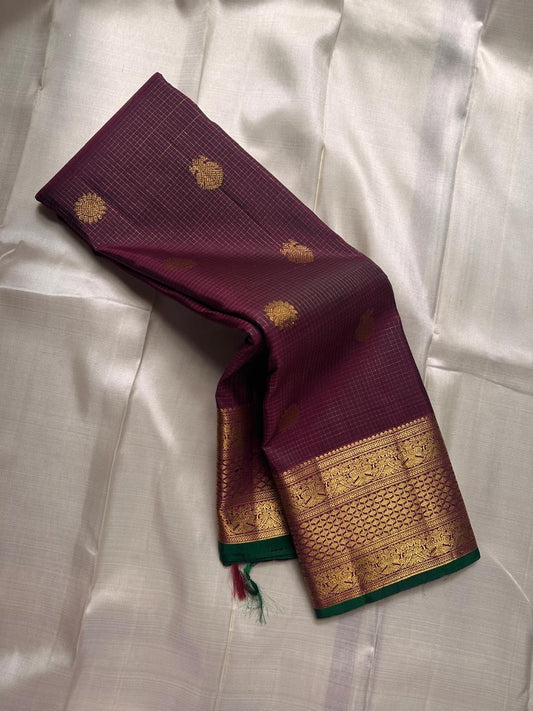 Madhuvanam — Pure Silk Kanchipuram Saree
Brownish-plum body with gold buttas & kattam checks ✨
Antique-gold korvai borders & grand magenta zari pallu 🌸
Silk Mark Certified • Ships in Two Weeks • Free Shipping within USA