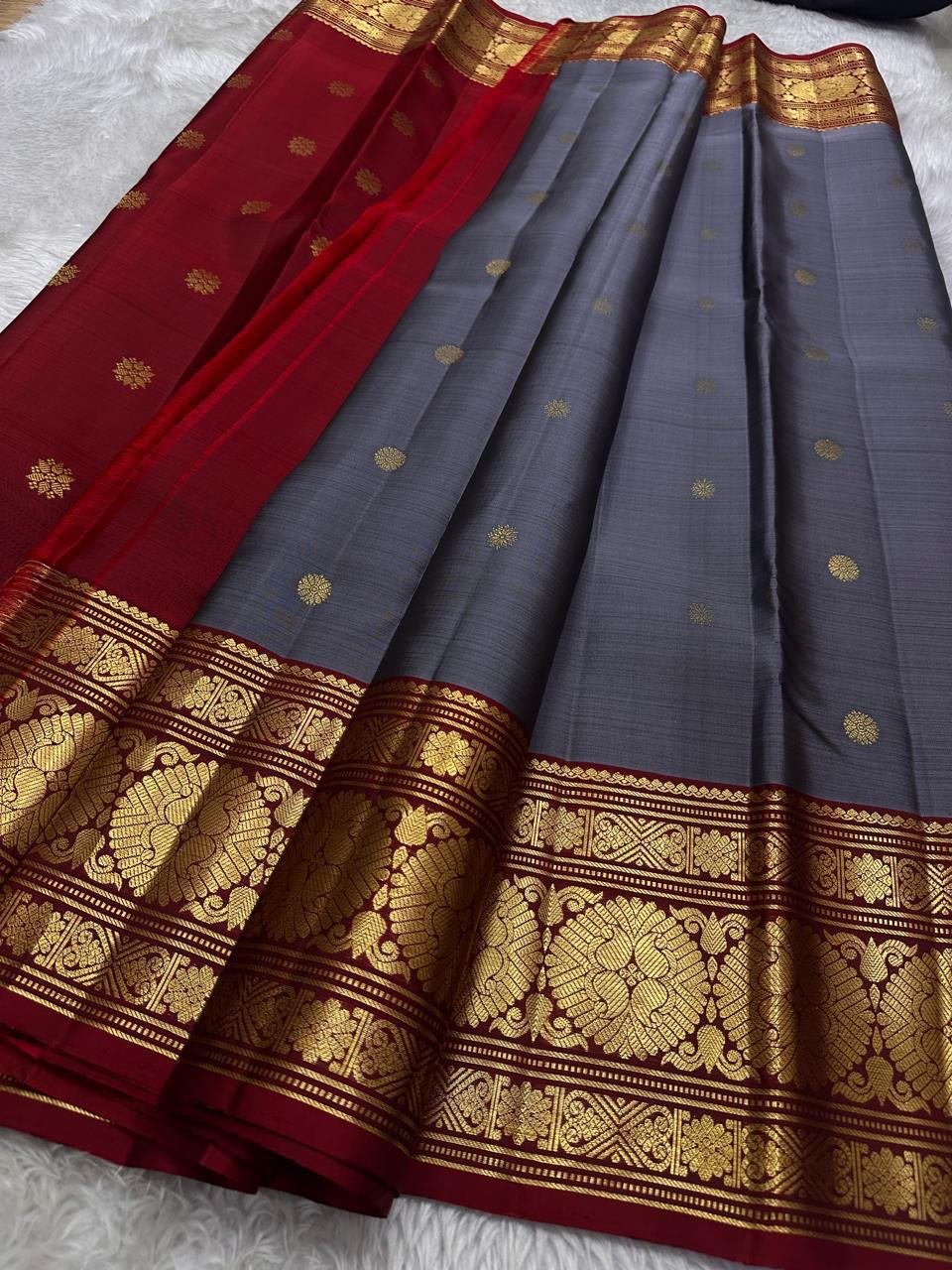 Aarohi – Ash Grey Pure Silk Kanchipuram Saree
Featuring a vibrant vermillion maroon red border and pallu.
Adorned with traditional mullai seer and intricate zari motifs.
A perfect blend of subtle elegance and festive vibrance.