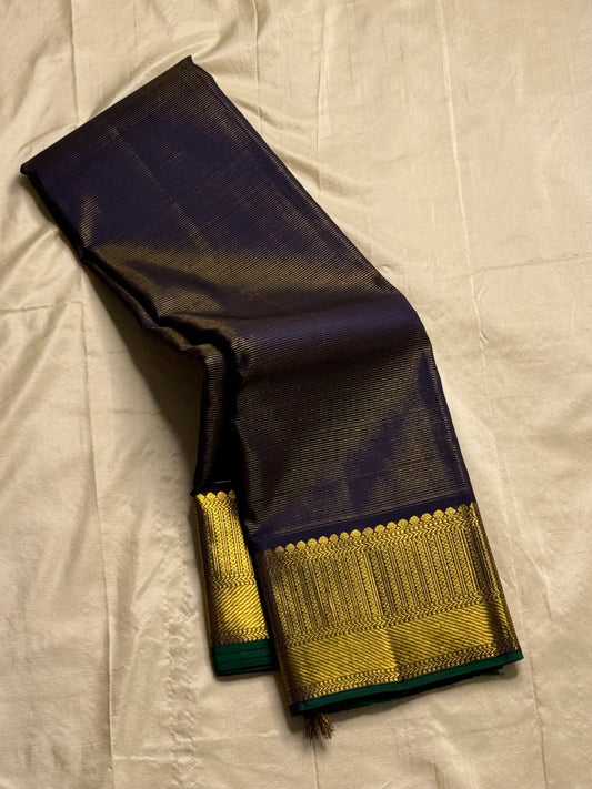 Krishna Shyama — Pure Silk Kanchipuram
Deepest purple “Shyama” body with Vairaoosi pinstripes
Temple-inspired antique gold zari borders with green selvedge
Grand striped zari pallu with hand-tied tassels
Silk Mark Certified • free shipping