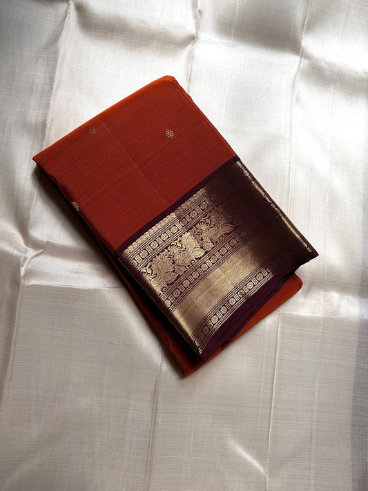 Rust Annam Butta — Kanchipuram Pure Silk
Rust-orange (semman/rust) body with zari chakram buttas
Deep maroon korvai borders with annam (swan) vine motifs
Lavish maroon-gold zari pallu with temple serrations
Silk Mark Certified | Free Shipping
