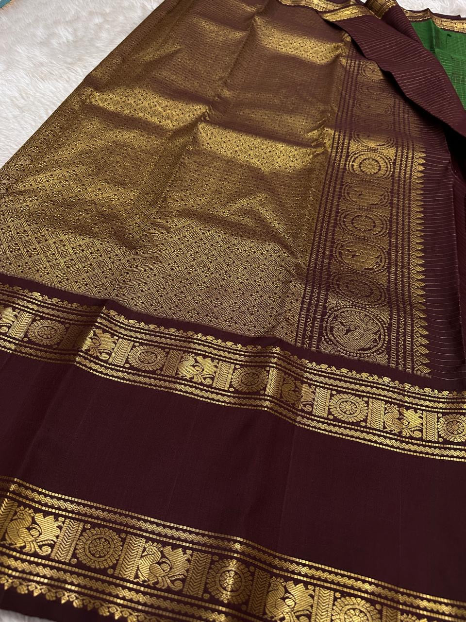 Geetham ✨
Forest Green Zari Kattam Pure Silk Kanchipuram Saree 🌿
With Ornate Rettapet Border of Peacock & Kamalam Motifs 🦚🌸
Flanked by Muthuseer Florals & Vanki Neli Columns 🌺
Finished with a Grand Brocade Maroon Pallu in Rich Zari ✨