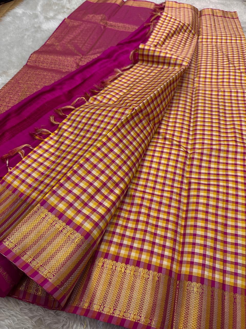 A classic Kanchipuram in Pattani Kattam checks with pink, magenta, mustard, and cream.
Finished with a contrast pink border and pallu.
Paisley and chakram motifs in a graceful grid add timeless charm.