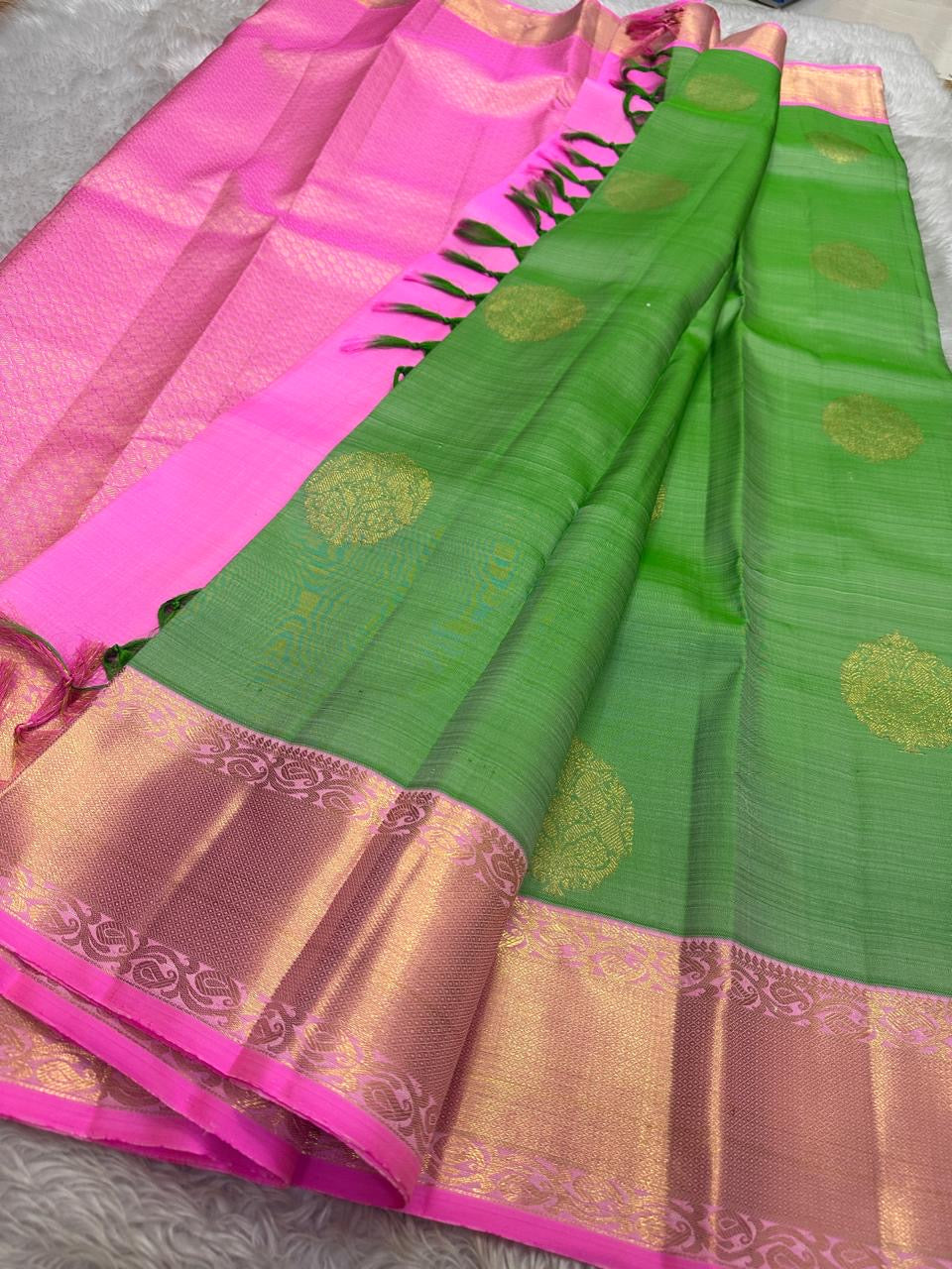 Asha ✨ – Fresh Green Pure Silk Kanchipuram Saree
with Radiant Pink Korvai Contrast Border
Gold Zari Floral Medallion Buttas on the Body
Grand Pink Brocade Pallu with Intricate Weaving