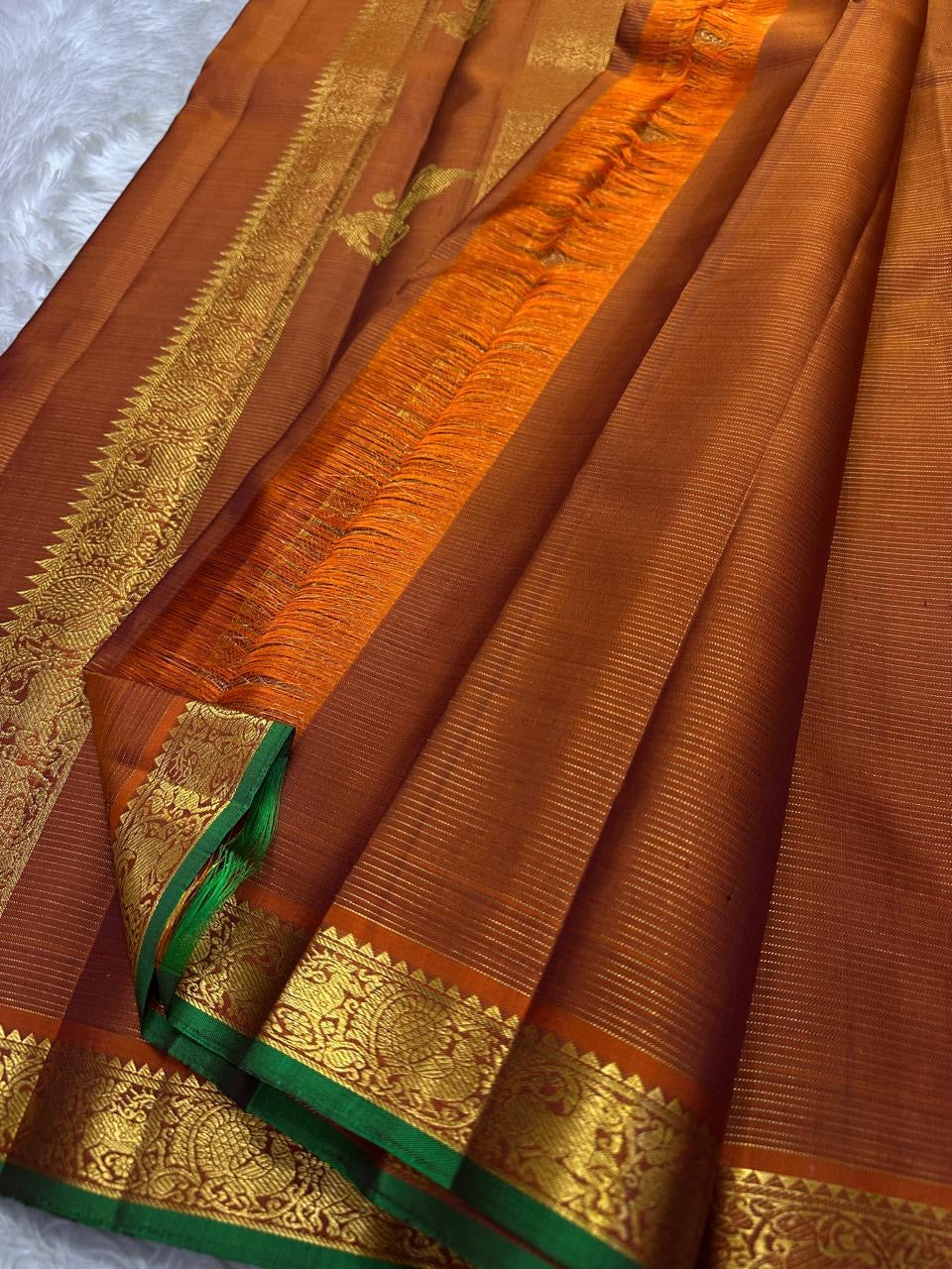 Rust Orange Yazhi Vairaoosi — Pure Silk Kanchipuram Saree
Rust orange body with fine vaira oosi lines and regal Yazhi zari motifs
Antique gold borders with green selvedge and grand brocade pallu ✨
Silk Mark Certified • Free USA Shipping • Ships in Two We
