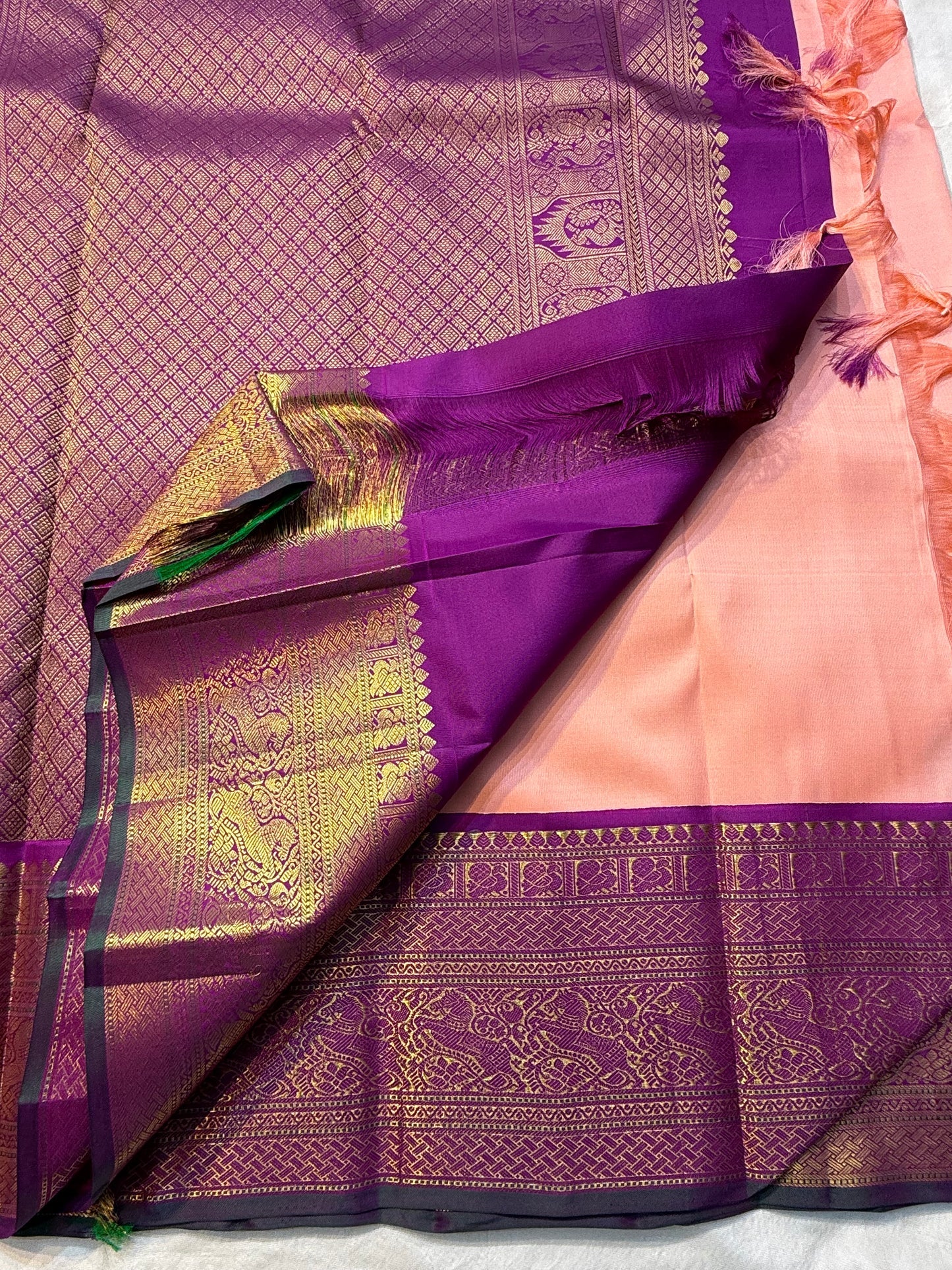 Apricot Yazhi — Pure Silk Kanchipuram Saree
Soft apricot-peach body with royal-purple korvai border featuring antique-gold Yazhi & Mayil motifs and temple edges.
Silk Mark Certified • Blouse Stitching ($30) • Free USA Shipping • Ships in 2 Weeks