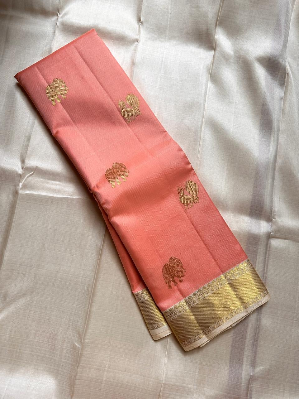 Ivory Blush Meadow – Pure Kanchipuram Silk Saree
Blush-Peach Body with Gold Zari Animal Buttas
Ivory-Gold Contrast Border with Floral Motifs
Grand Ivory-Gold Brocade Pallu in Traditional Weave
Silk Mark Certified, delivery in 2 weeks