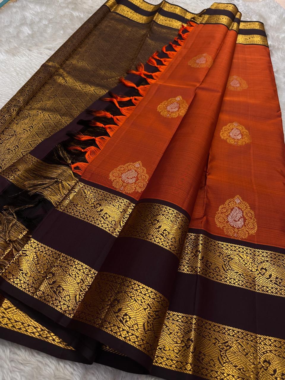 The Rust Orange Abharna: A Silk Mark Certified Kanchipuram Pure Silk Saree
with Maroon and Gold Elephant Zari Border & Rich Zari Pallu
Handwoven with Exquisite Peacock Motifs
Free Shipping within USA on this Handloom Creation
Ships in 1 Week