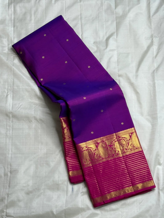 Classic Amethyst — Pure Silk Kanchipuram Saree
Royal violet body with gold muthu buttas & rani-magenta elephant zari borders
Silk Mark Certified • Free USA Shipping • Ships in Two Weeks