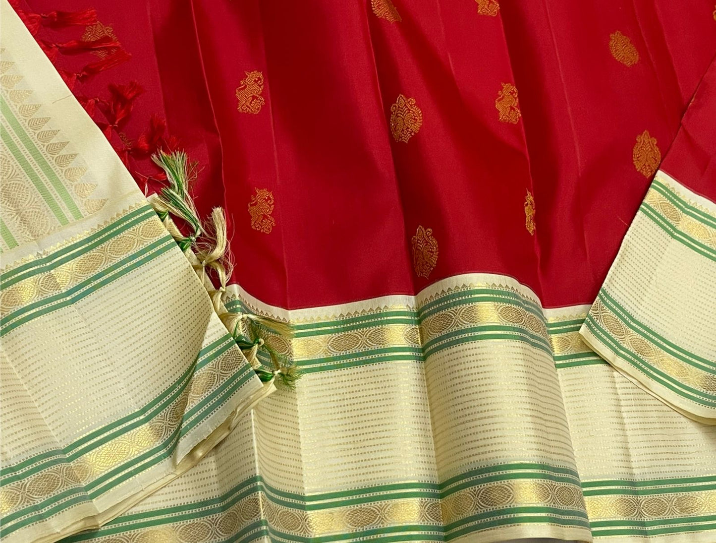 Yazhi Venpattu — Pure Silk Kanchipuram
Kumkum-red body with gold mankolam buttas & ivory korvai borders in mint-green lines ✨
Silk Mark Certified • Ships in Two Weeks • Free Shipping within USA