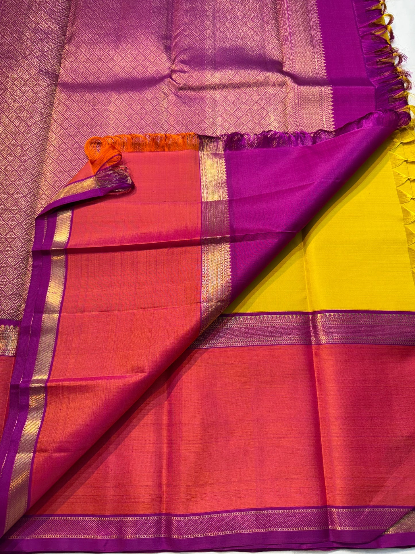 Mangai Manjal Chakram — Kanchipuram Pure Silk
Sun-yellow body with tiny zari buttas • Korvai contrast border
Rani-pink shot with purple selvedge • chakram medallions
Vaira-oosi diamond pallu with dual-tone tassels
Silk Mark Certified • Free shipping
