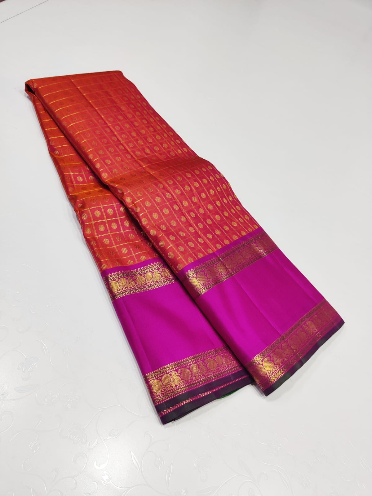 Ruby Orchid kattam – Pure Kanchipuram Silk Saree
Radiant red-orange body with fine kattam checks & zari buttas ✨
Striking magenta 2G Korvai borders woven with floral zari artistry
Silk Mark Certified, delivery in 2 weeks