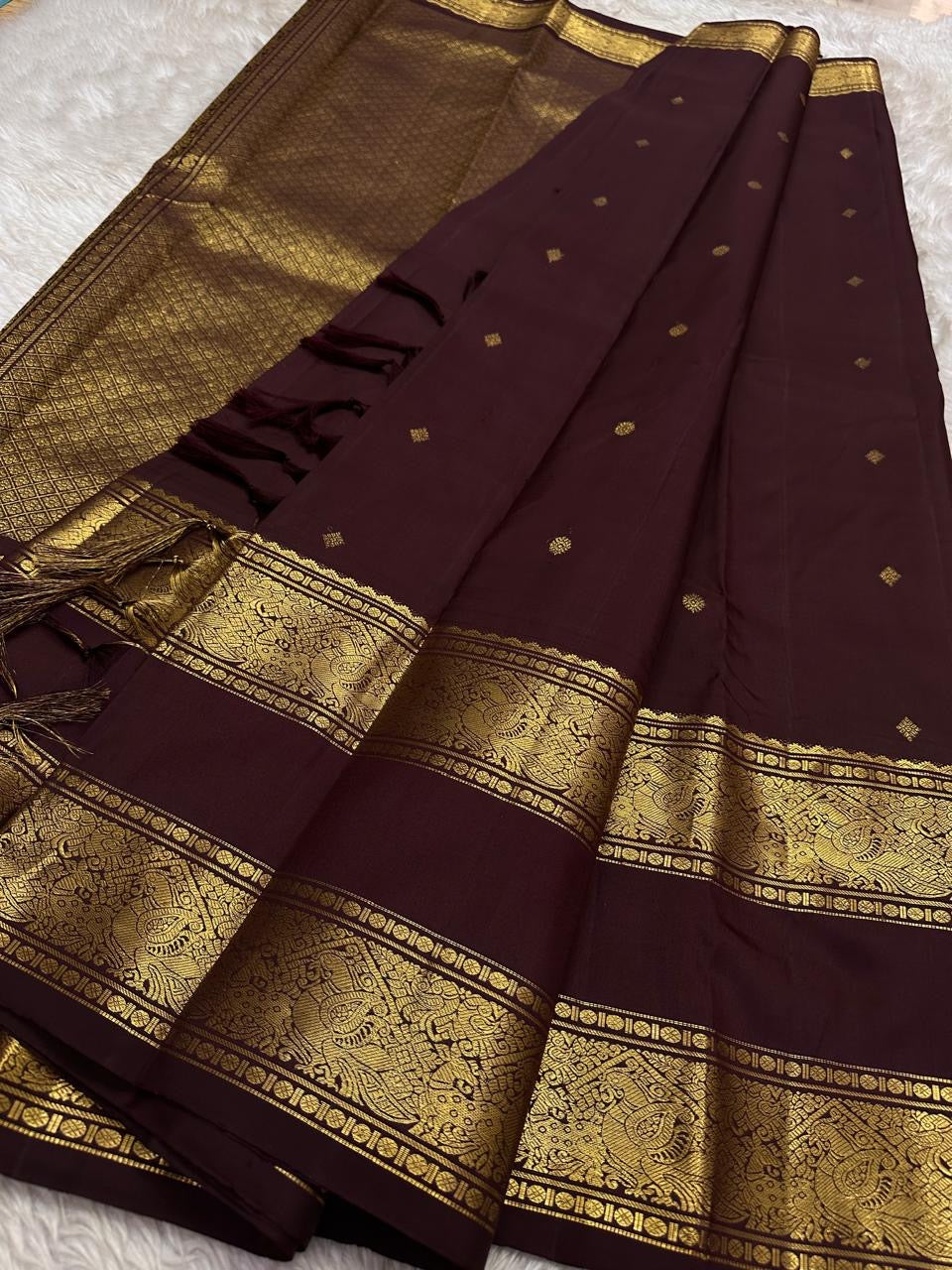 Kasturi 🌰✨
Deep Coffee Brown Pure Silk Kanchipuram Saree
Gold Zari Woven Kamalam & Diamond Buttas All Over
Double Border with Mayil Pettu & Rettapettu Detailing
Diagonal Peacock Pallu with Floral Vine Motifs