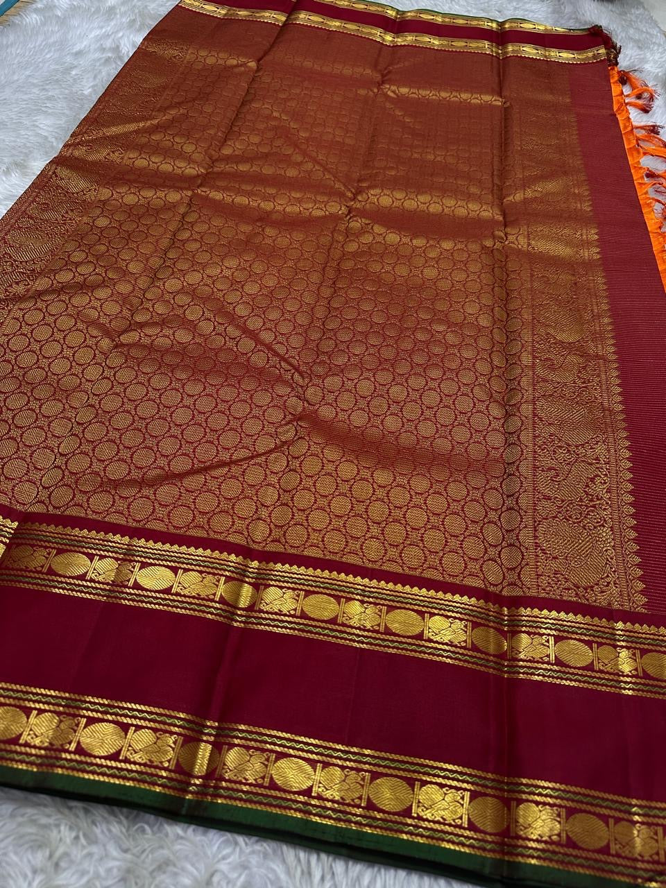 Vasantha Malli ✨ — Pure Silk Kanchipuram
Sunset-orange body with fine textured weave 🌸
Deep maroon borders with kasu zari & temple motifs ✨
Grand brocade pallu with traditional circular jaal 🪔 Perfect for Diwali & festive drapes
Silk Mark Certified • Fr