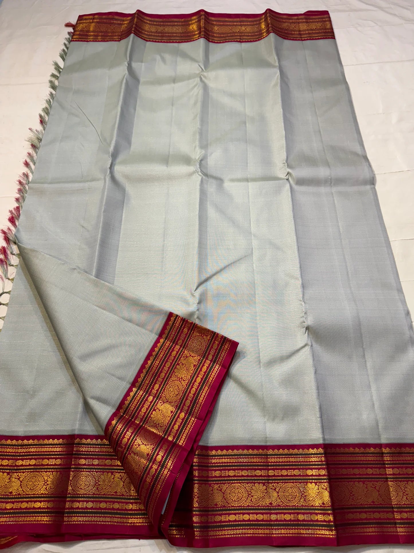 Velli Rekha — Pure Silk Kanchipuram Saree
Silver-grey body with gold buttas ✨
Arakku red korvai borders & rich zari pallu
Silk Mark Certified ✅ | Ships in 2 Weeks | Free USA Shipping 🇺🇸