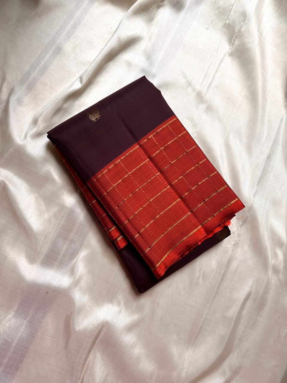 Minmini – Deep brown Pure Kanchipuram Silk Saree with Gold Zari Buttas, Vibrant Orange Checked Border in Zari Kattam Weave & Ornate Gold Brocade Pallu with Traditional Motifs