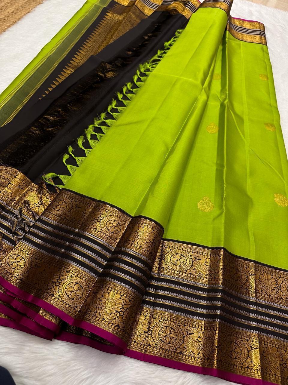 Kili Pachai — Pure Silk Kanchipuram Saree
Parrot-Green Body with Gold Buttas ✨
Black Korvai Borders with Peacock Medallions 🦚
Black Brocade Pallu • Contrast Black Blouse with Zari 🌸
Silk Mark Certified • Free Shipping within USA • Ships in Two Weeks