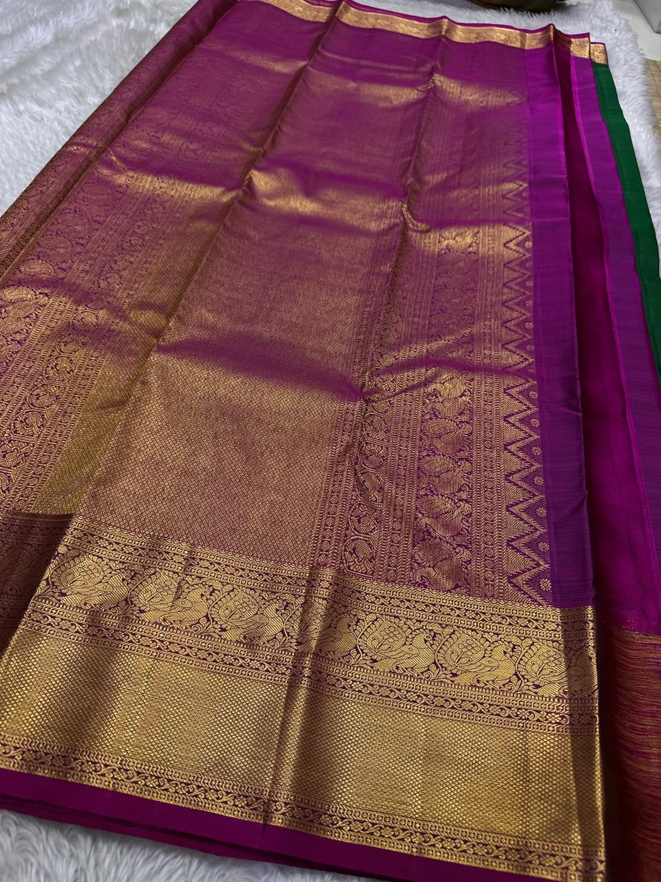 Maragatha Mayil Butta — Kanchipuram Pure Silk
Emerald green (maragatham) body with gold mayil/peacock buttas
Contrast rani-magenta korvai borders & zari-rich pallu
Silk Mark Certified | Free Shipping within USA