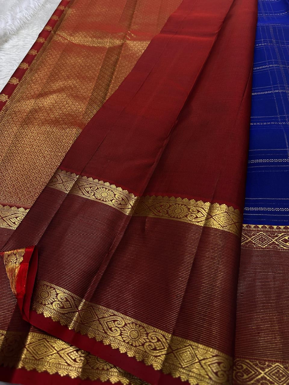 Sapphire Ruby Kattam – Pure Kanchipuram Silk Saree
sapphire blue body with gold kattam checks & buttas
Contrast ruby-red korvai borders with intricate gold zari weave
Grand ruby-red pallu with floral motifs
Silk Mark Certified | ships in 2 weeks