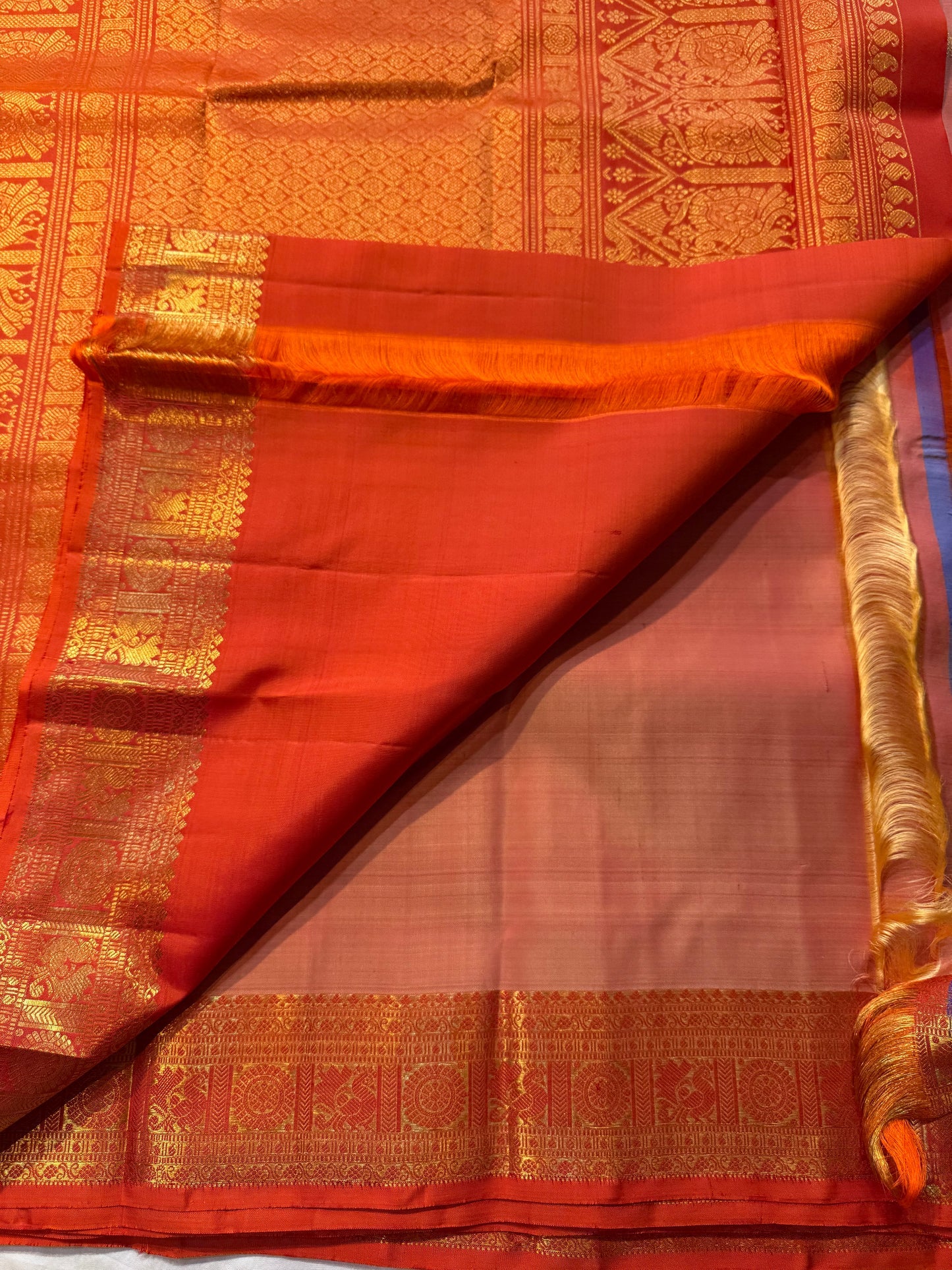 Mandara Peach – Pure Korvai Kanchipuram Silk Saree
Soft peach shot body with dainty gold chakram buttas
Vermilion-orange korvai borders with peacock medallions
Grand kumkumam red pallu with full zari brocade & temple panels
Silk Mark Certified | Free Ship