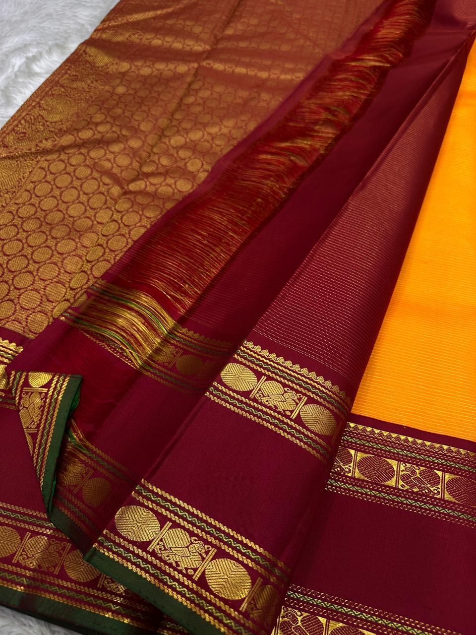 Vasantha Malli ✨ — Pure Silk Kanchipuram
Sunset-orange body with fine textured weave 🌸
Deep maroon borders with kasu zari & temple motifs ✨
Grand brocade pallu with traditional circular jaal 🪔 Perfect for Diwali & festive drapes
Silk Mark Certified • Fr