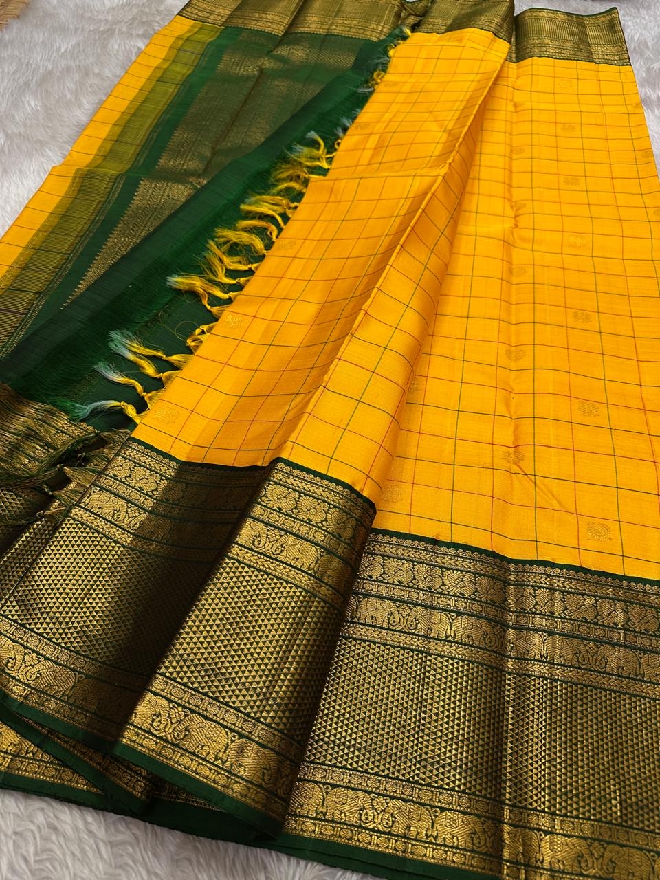 Manjal Pachai Kattam
Pure Kanchipuram Silk Saree – Marigold Yellow Body with Green Checks & Petite Zari Buttas
Deep Green Korvai Borders with Rich Gold Zari Weave & Traditional Elephant Motifs
Silk mark certified , ships in 2 weeks