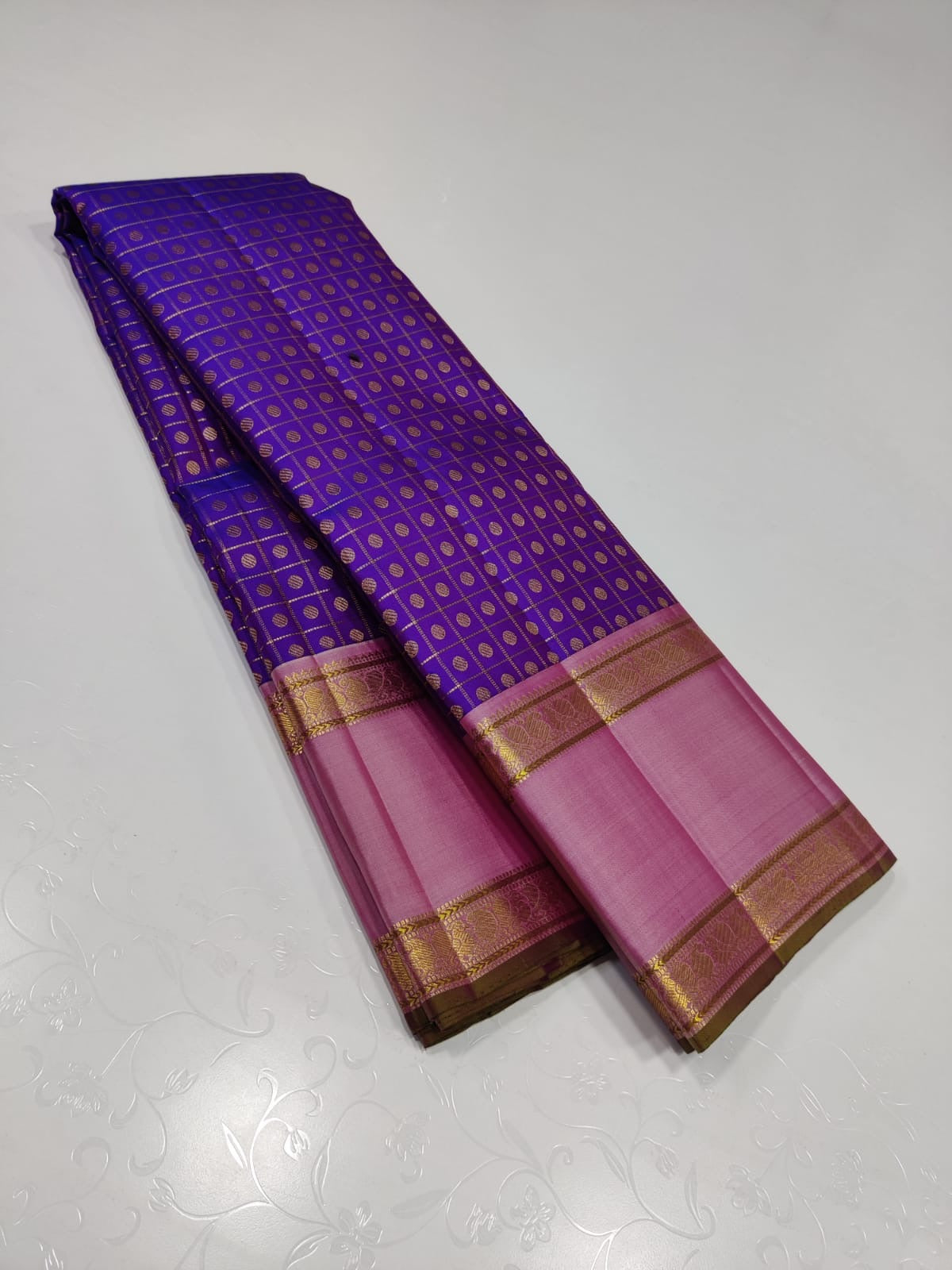 Violet Bloom – Pure Kanchipuram Silk Saree
Royal purple body in fine kattam checks with oval buttas ✨
Rose-pink korvai borders in ornate 2g zari
Silk Mark Certified, delivery in 2 weeks