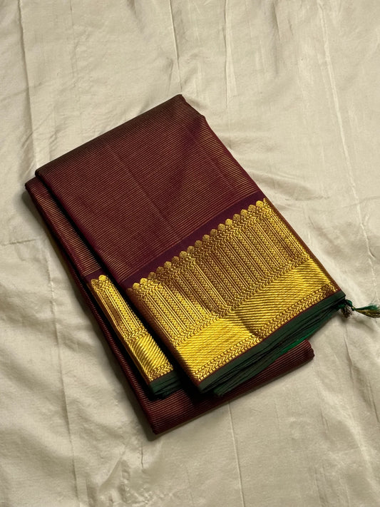 Shyama Vairaoosi — Pure Silk Kanchipuram
Deep Shyama brown with micro Vairaoosi pinstripes
Temple-column antique gold zari border, bottle-green selvedge
 Grand striped zari pallu with hand-tied tassels
Silk Mark Certified • free shipping