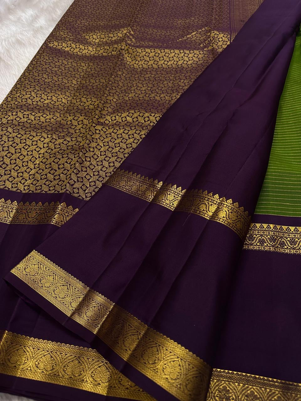 Iravati – Earthy Green Kanchipuram Pure Silk Saree
A graceful weave in a rare earthy green tone, adorned with gold zari kattam and butta.
Accented by a rich plum rettapet border with delicate flower vine motifs.