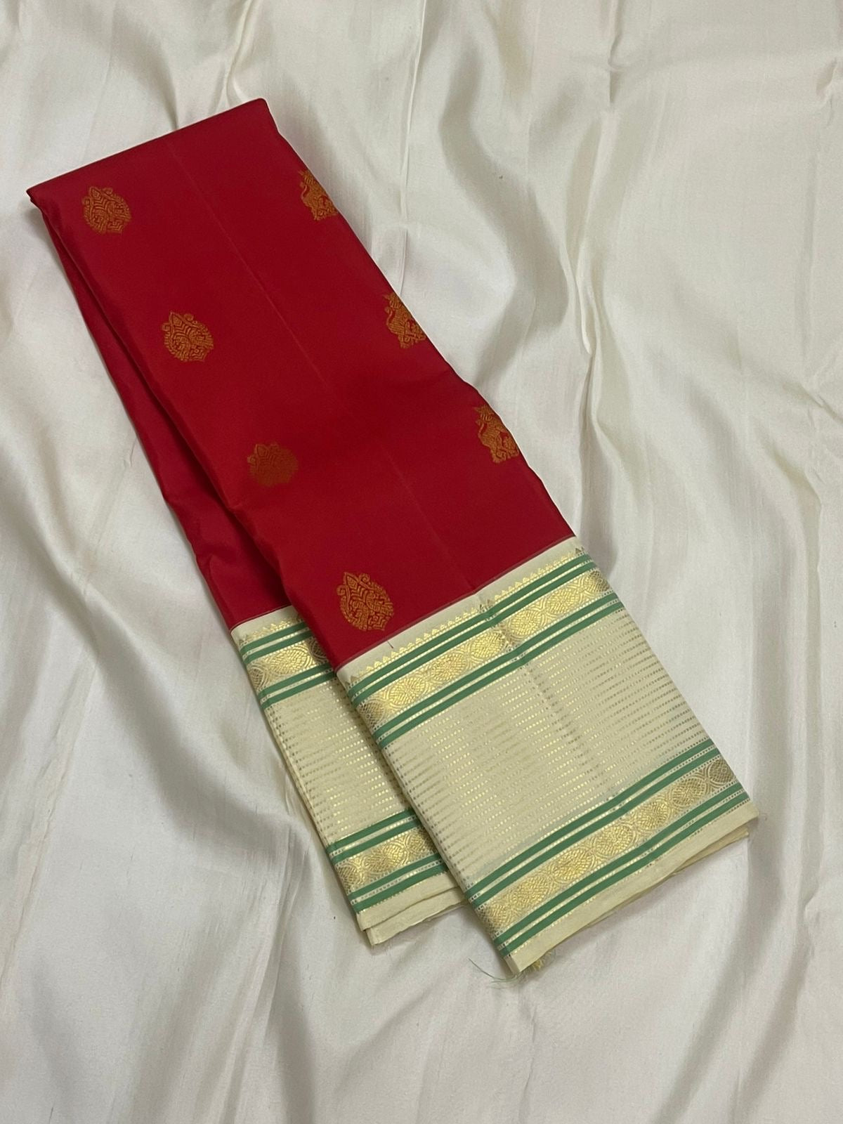 Yazhi Venpattu — Pure Silk Kanchipuram
Kumkum-red body with gold mankolam buttas & ivory korvai borders in mint-green lines ✨
Silk Mark Certified • Ships in Two Weeks • Free Shipping within USA