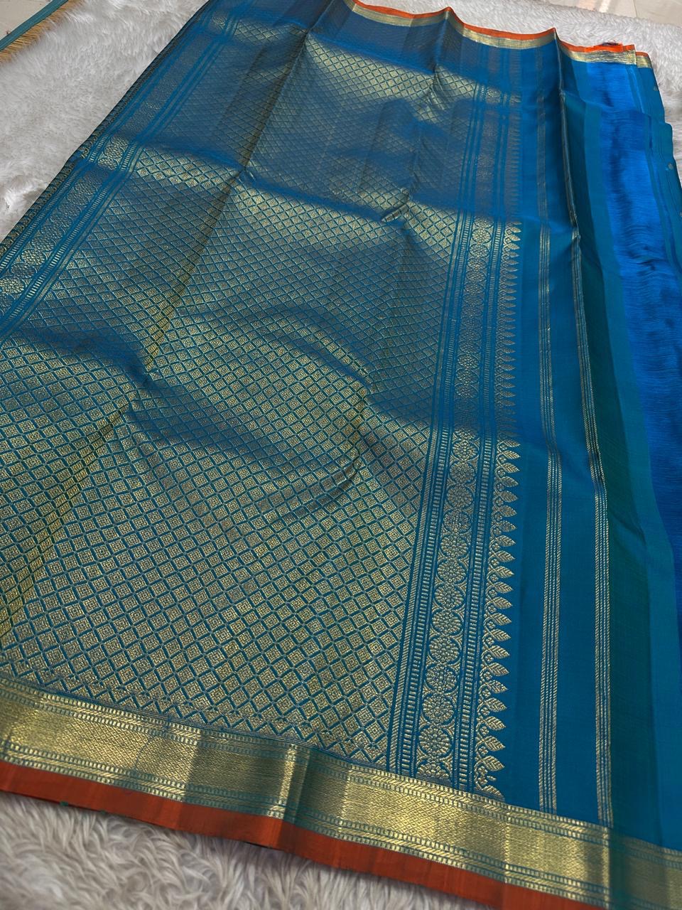 Peacock Teal Ilai Butta – serene teal body with copper-gold zari borders
Pure Kanchipuram silk • dainty leaf (ilai) buttas scattered across the body
Rich teal zari pallu
Silk Mark Certified | Fall & Pico Done | Blouse Stitching Available ($30)