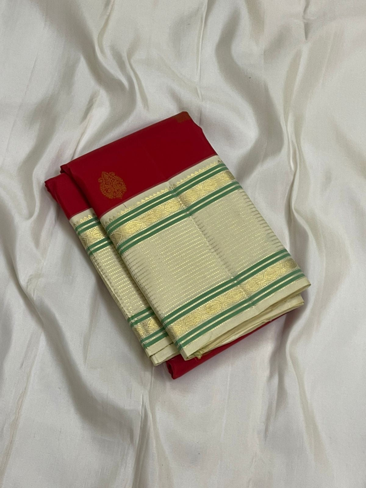 Yazhi Venpattu — Pure Silk Kanchipuram
Kumkum-red body with gold mankolam buttas & ivory korvai borders in mint-green lines ✨
Silk Mark Certified • Ships in Two Weeks • Free Shipping within USA