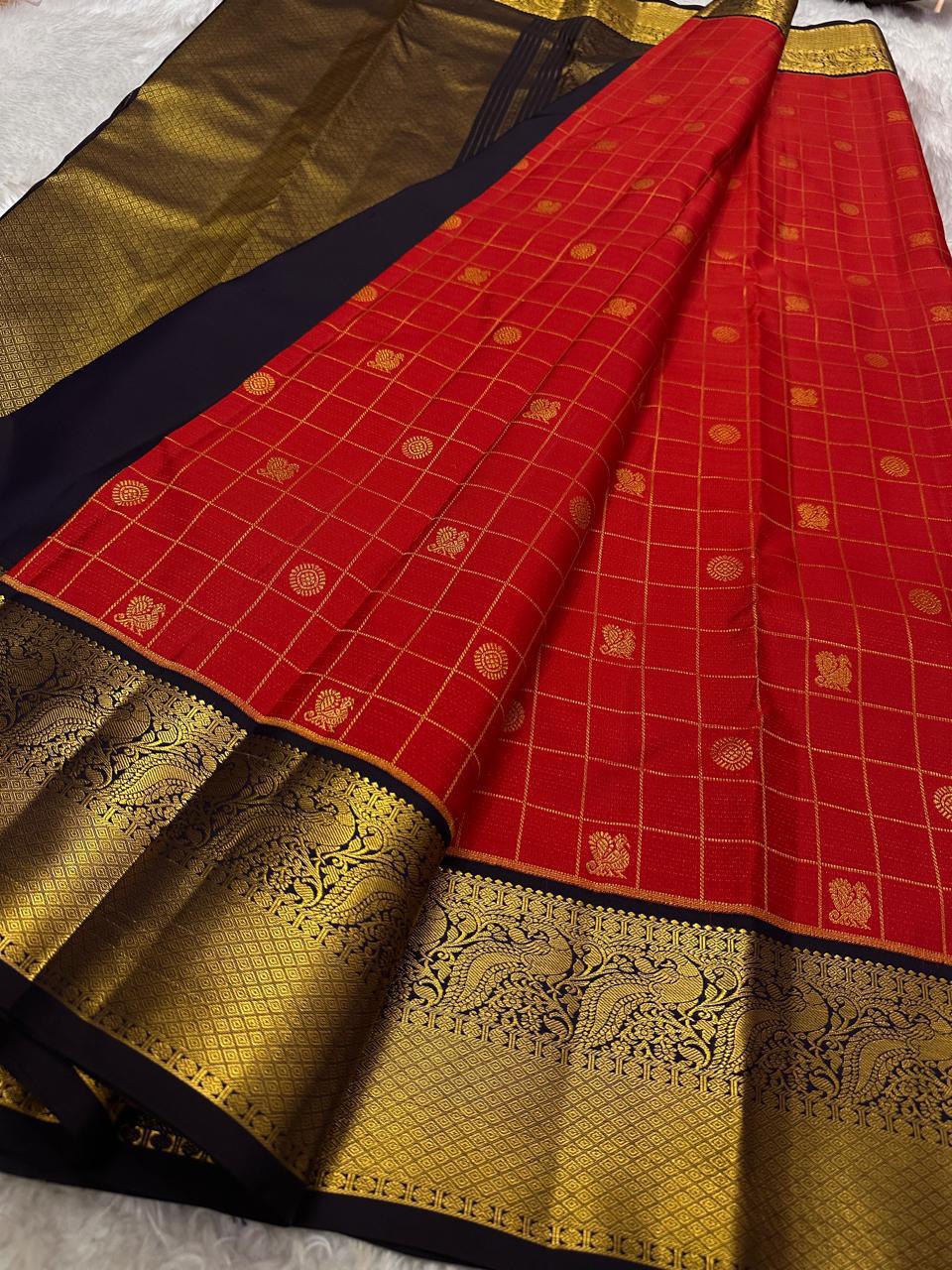 Ranga - A vivid red pure silk Kanchipuram saree featuring intricate zari kattam with traditional mayil, chakram, butta, and vanasringaram motifs across the body. The contrast jamun dark blue border and pallu are woven with exquisite Annam motifs
