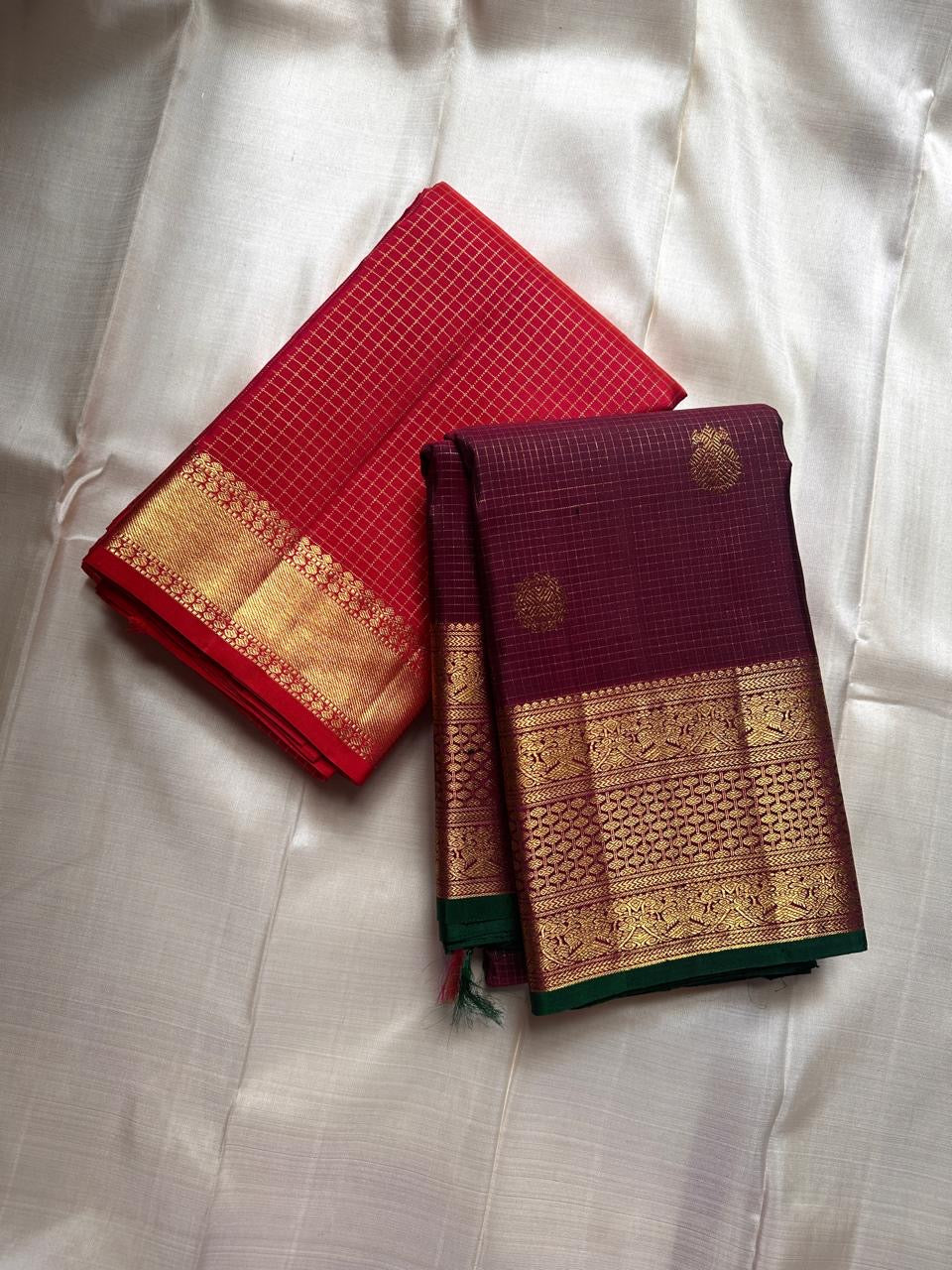 Madhuvanam — Pure Silk Kanchipuram Saree
Brownish-plum body with gold buttas & kattam checks ✨
Antique-gold korvai borders & grand magenta zari pallu 🌸
Silk Mark Certified • Ships in Two Weeks • Free Shipping within USA