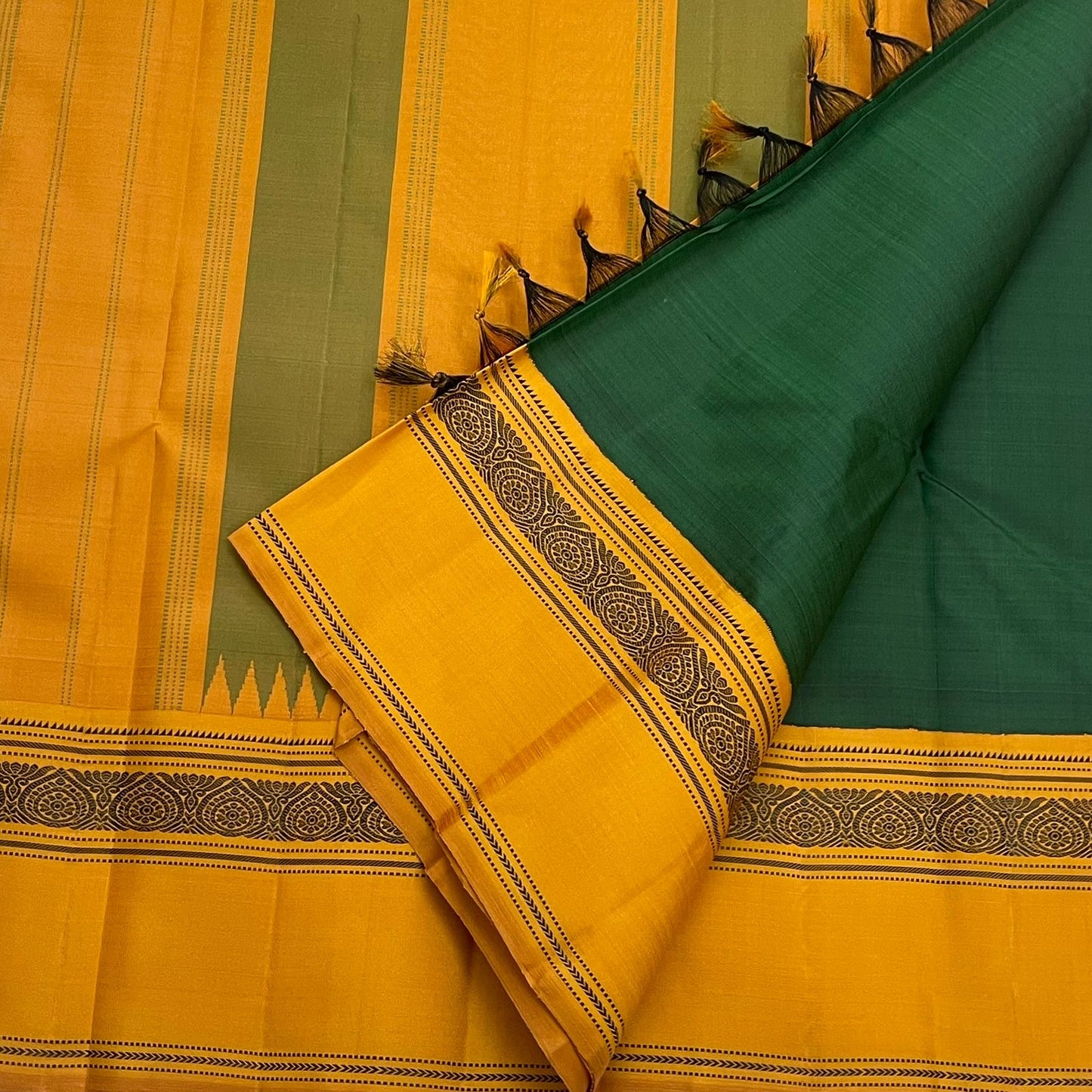 Maragatham & Mustard — Pure Silk Kanchipuram Saree
Emerald-green body with mustard korvai borders & floral medallion vines, varisaipettu pallu with tassels.
Silk Mark Certified • Ships in Two Weeks • Free USA Shipping ✅