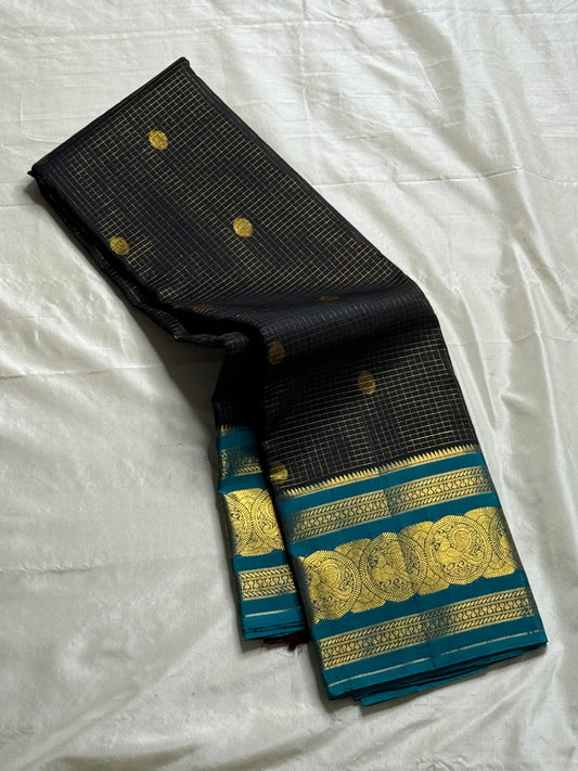 Karuppu Pakshi Kattam – Pure Korvai Kanchipuram Silk Saree
Charcoal black podi kattam body with coin-gold buttas
Peacock-teal korvai border & pallu with pakshi medallion zari
Silk Mark Certified | Blouse Piece Included | Fall & Pico Done
Free Shipping