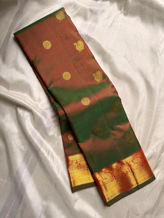 ✨ Manthulir Deepam — Pure Silk Kanchipuram Saree ✨
Dual-tone bottle green with rust-copper korvai border, gold zari coin & mango buttas, and a grand brocade pallu.
Silk Mark Certified • Free USA Shipping • Ships in 2 Weeks • Blouse Stitching $30 ✅